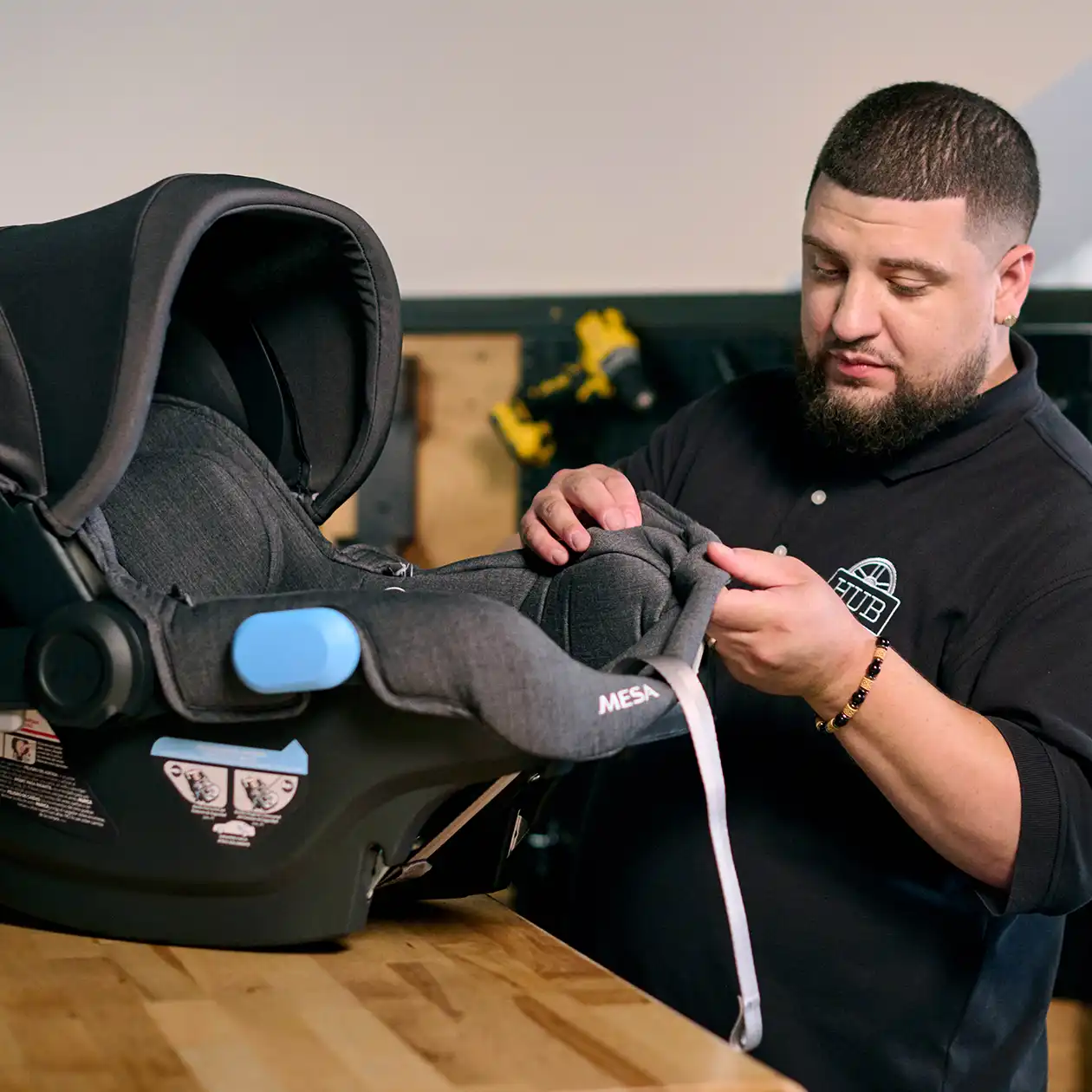 UPPAbaby Service Center technician thoughtfully inspecting Mesa infant car seat