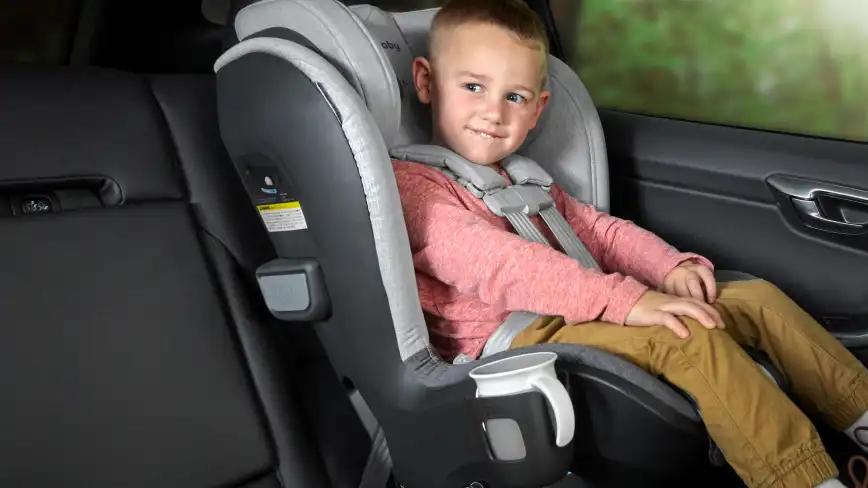 Child sitting in Knox with bottle in Cup Holder