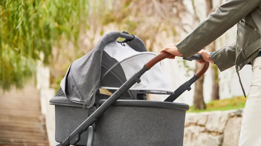 Parent pushes infant in Bassinet with Rain Shield attached to stroller stroller frame