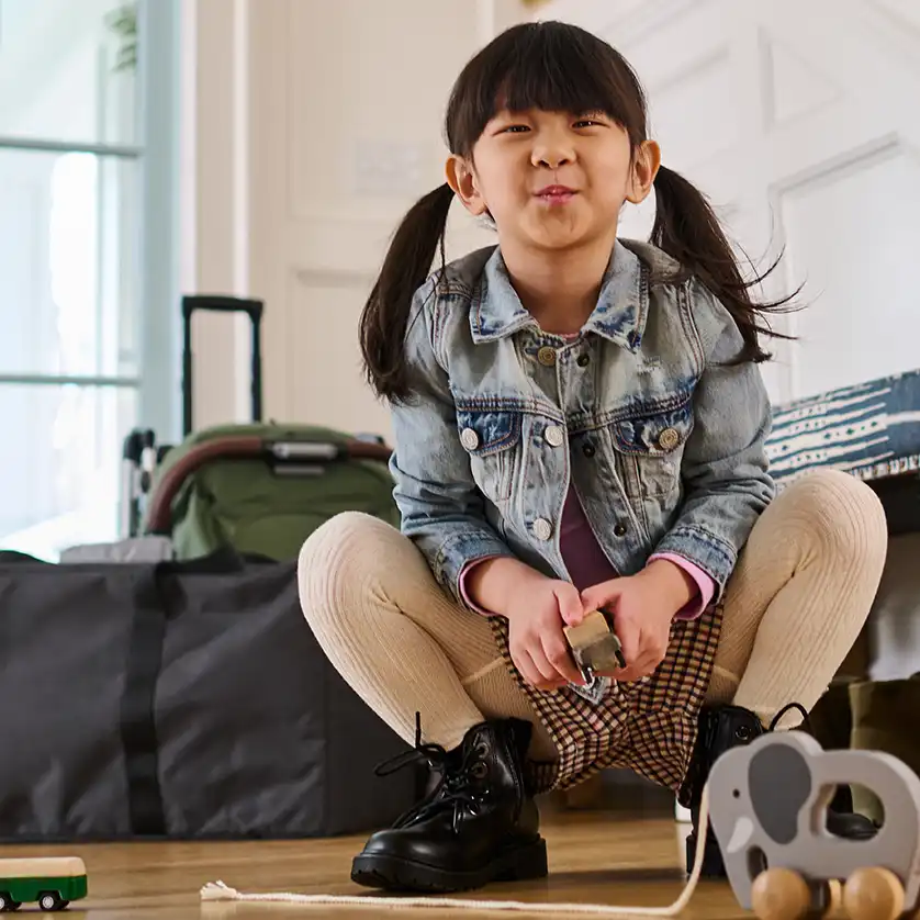 Young child kneeling beside a Remi TravelSafe bag with Remi stored inside