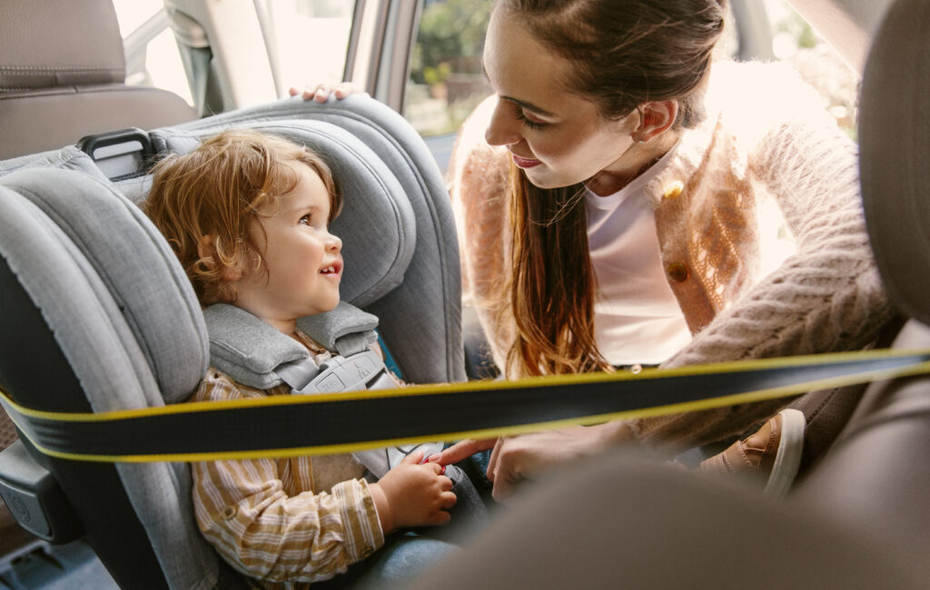 A mother securing her little one into an UPPAbaby Knox Convertible Car Seat.