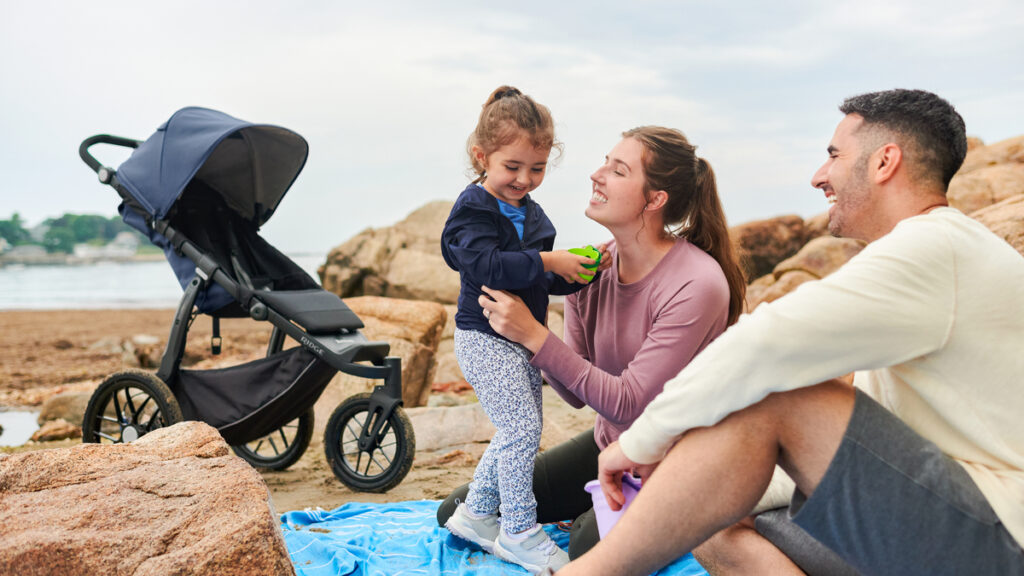 Happy parents adventuring with her little one with an UPPAbaby Ridge Stroller.