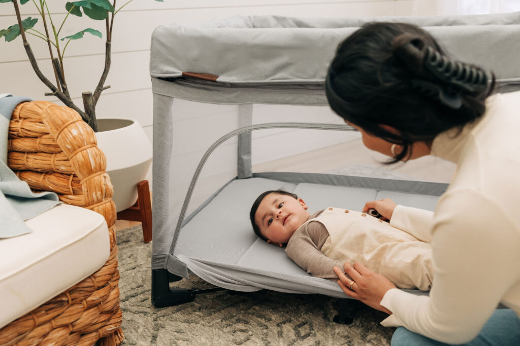 A child laying down in their UPPAbaby Remi Playard.