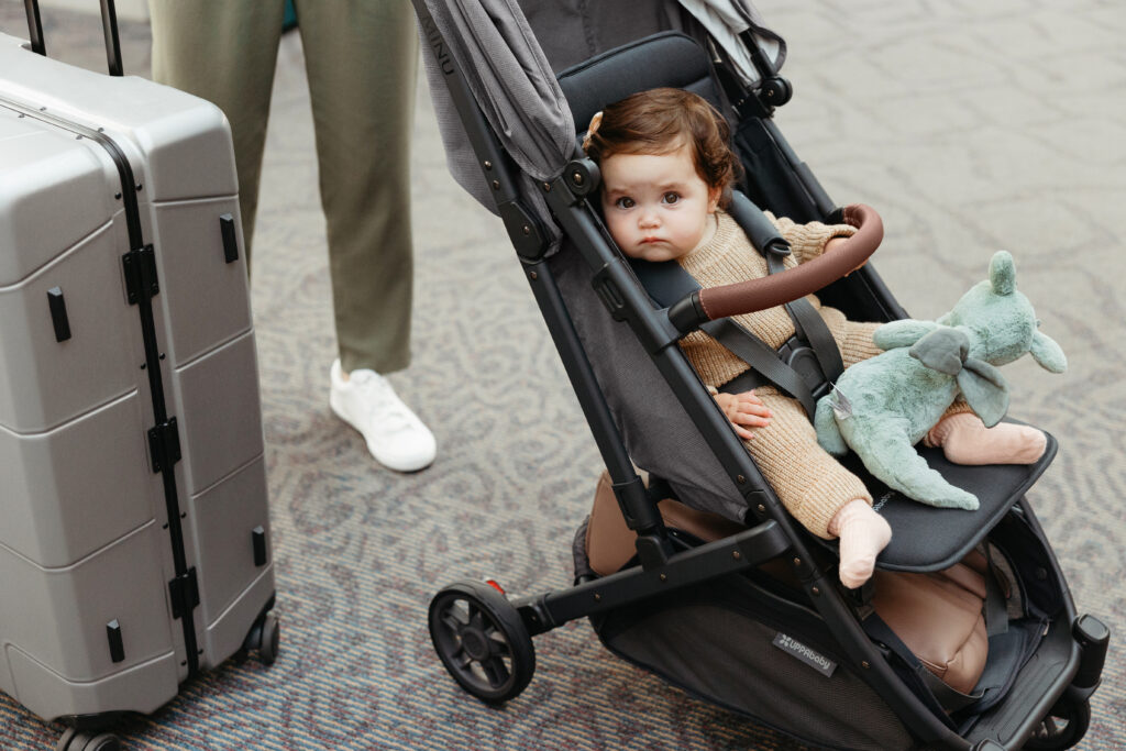 A small child is comfortable and cruising in the airport.