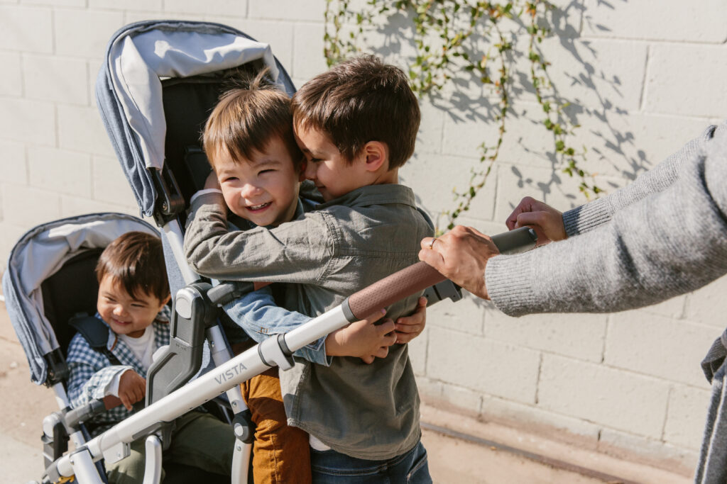 Three children ride on a triple configuration Vista while strolling along