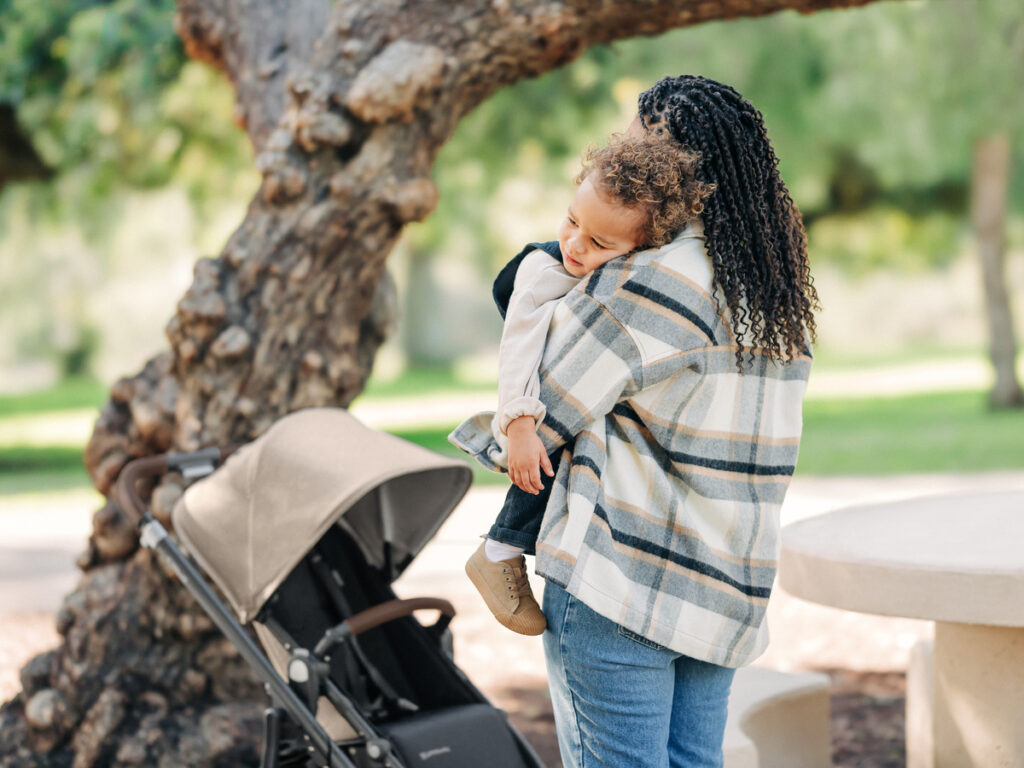 Mom embraces child after a long walk in the park in the Liam Cruz V2 stroller