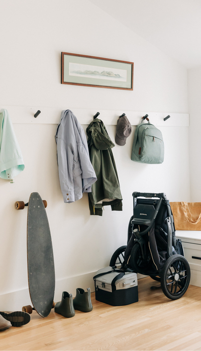 A lively entryway complete with a folded Ridge jogging stroller, changing backpack, and Bevvy cooler, all ready for some on-the-go adventures