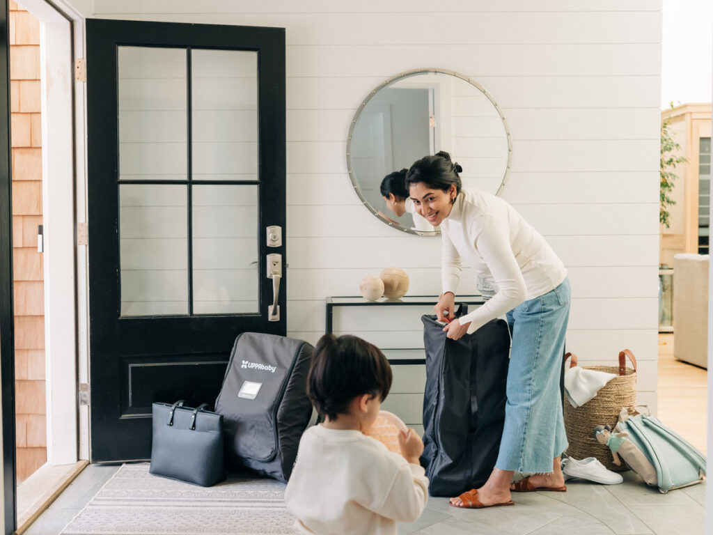 While her child plays, a woman effortlessly begins to pack up her lightweight Remi, placing it into the storage bag