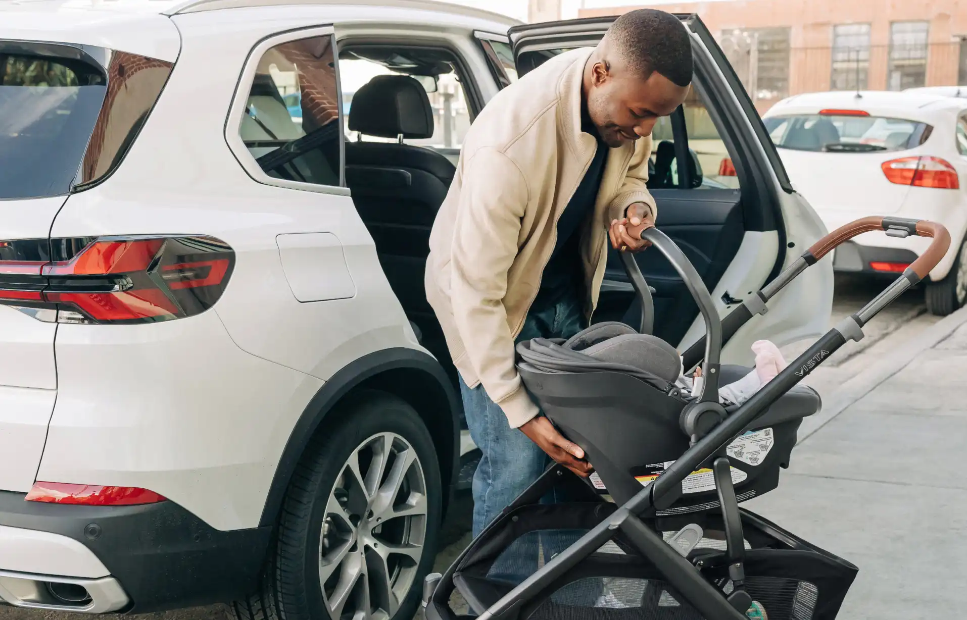 Dad unloading infant from car and directly attaching infant car seat to Vista V3 stroller frame