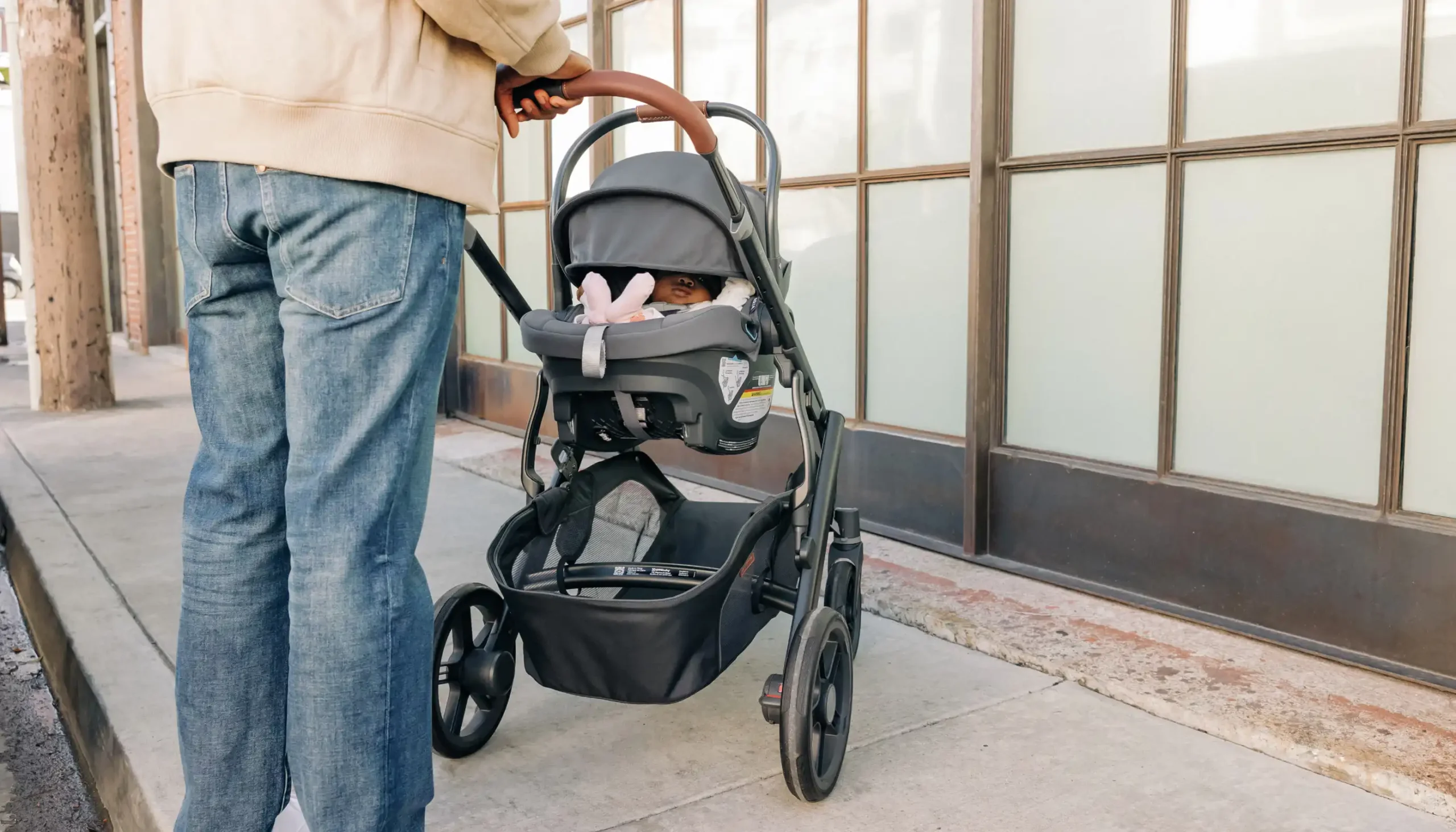 Parent pushing Vista V3 stroller with baby in Aria infant car seat directly attached to stroller frame