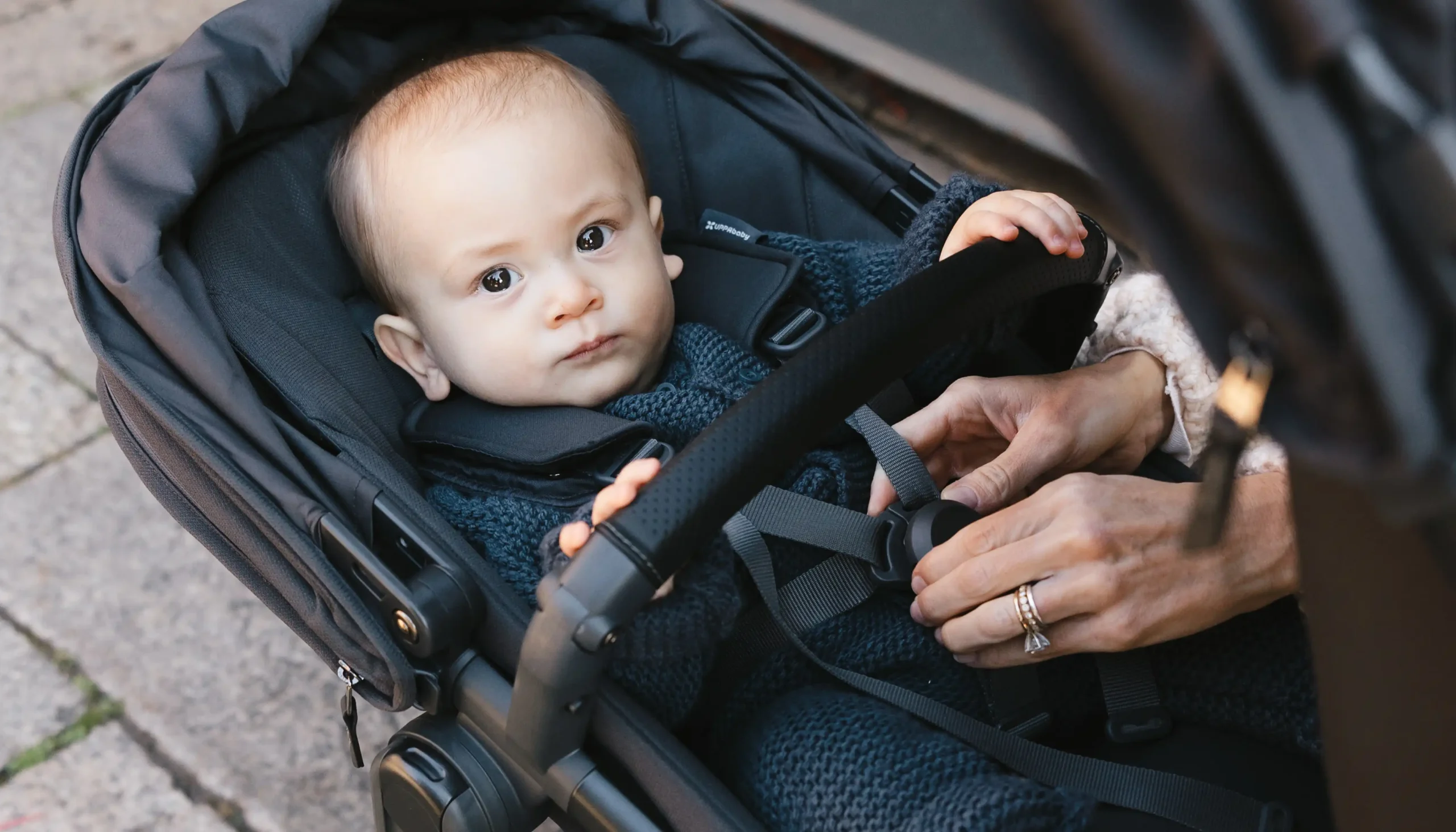 An infant is securely buckled into their RumbleSeat